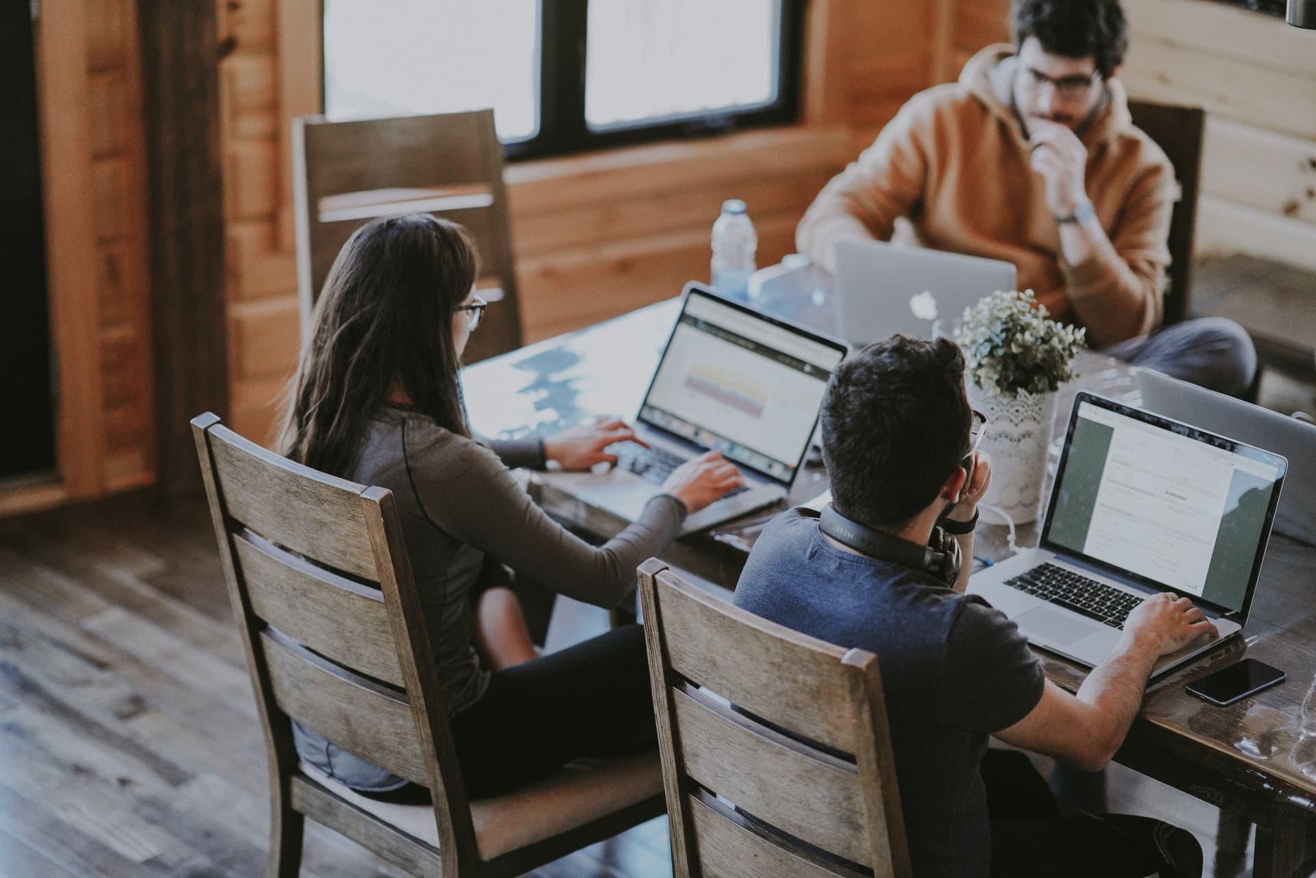 Team with 4 persons working on the same table on computers